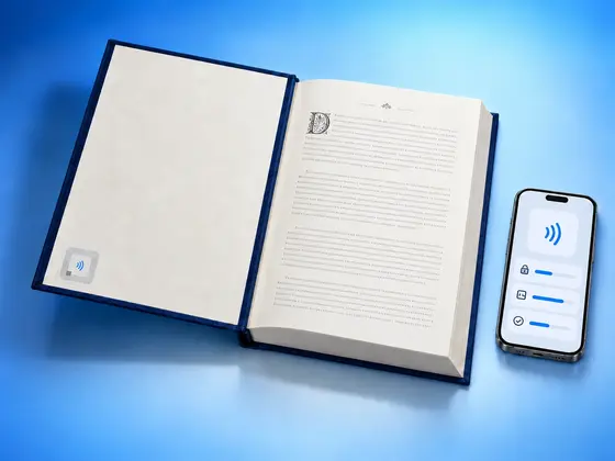 A library book with an RFID label inside its cover next to an iPhone showing the details of an NFC tag